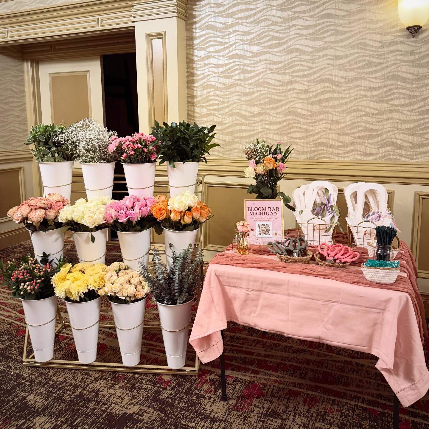 Bloom Bar setup with pink draped table and favor bags in an elegant ballroom