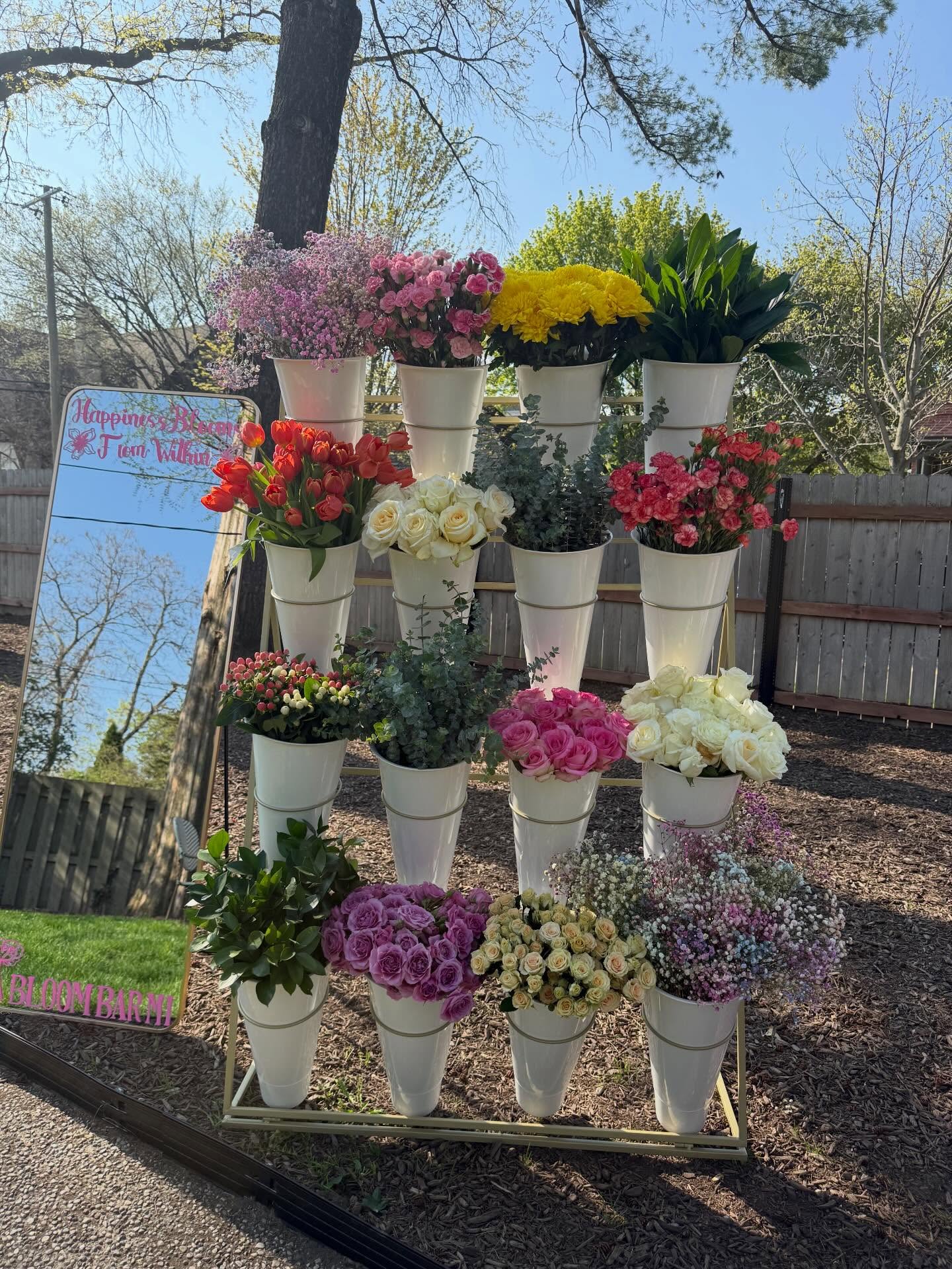 Outdoor Bloom Bar with colorful buckets of tulips, roses and mums