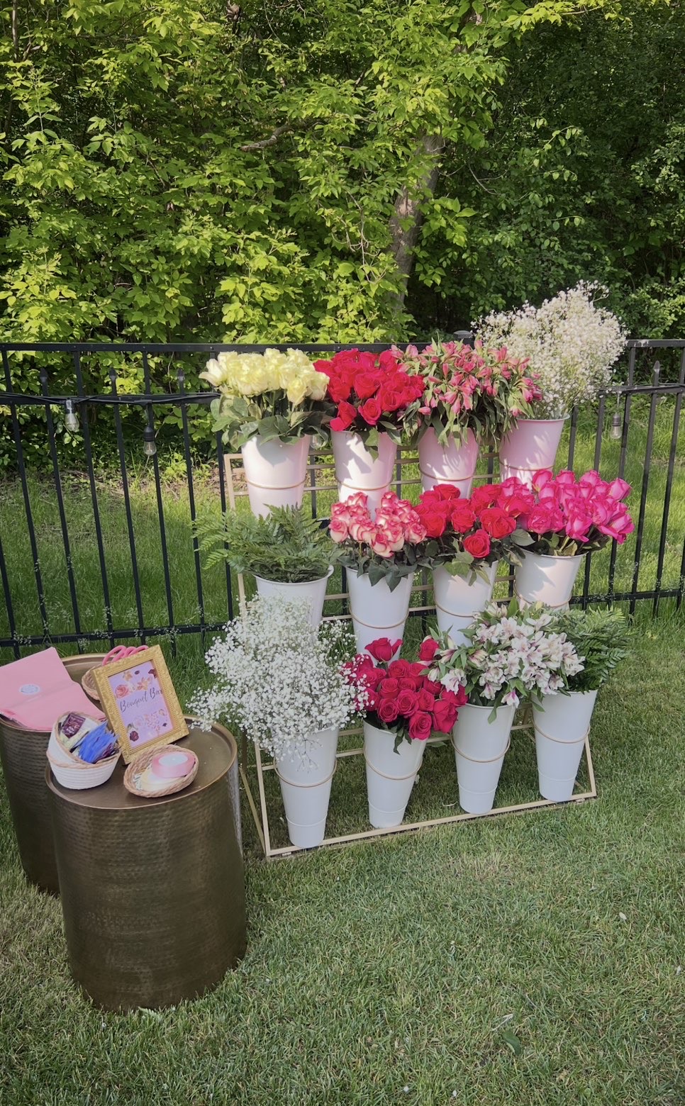 Satin-draped Bloom Bar with white buckets of hot pink roses, baby's breath and alstroemeria beside gold tables