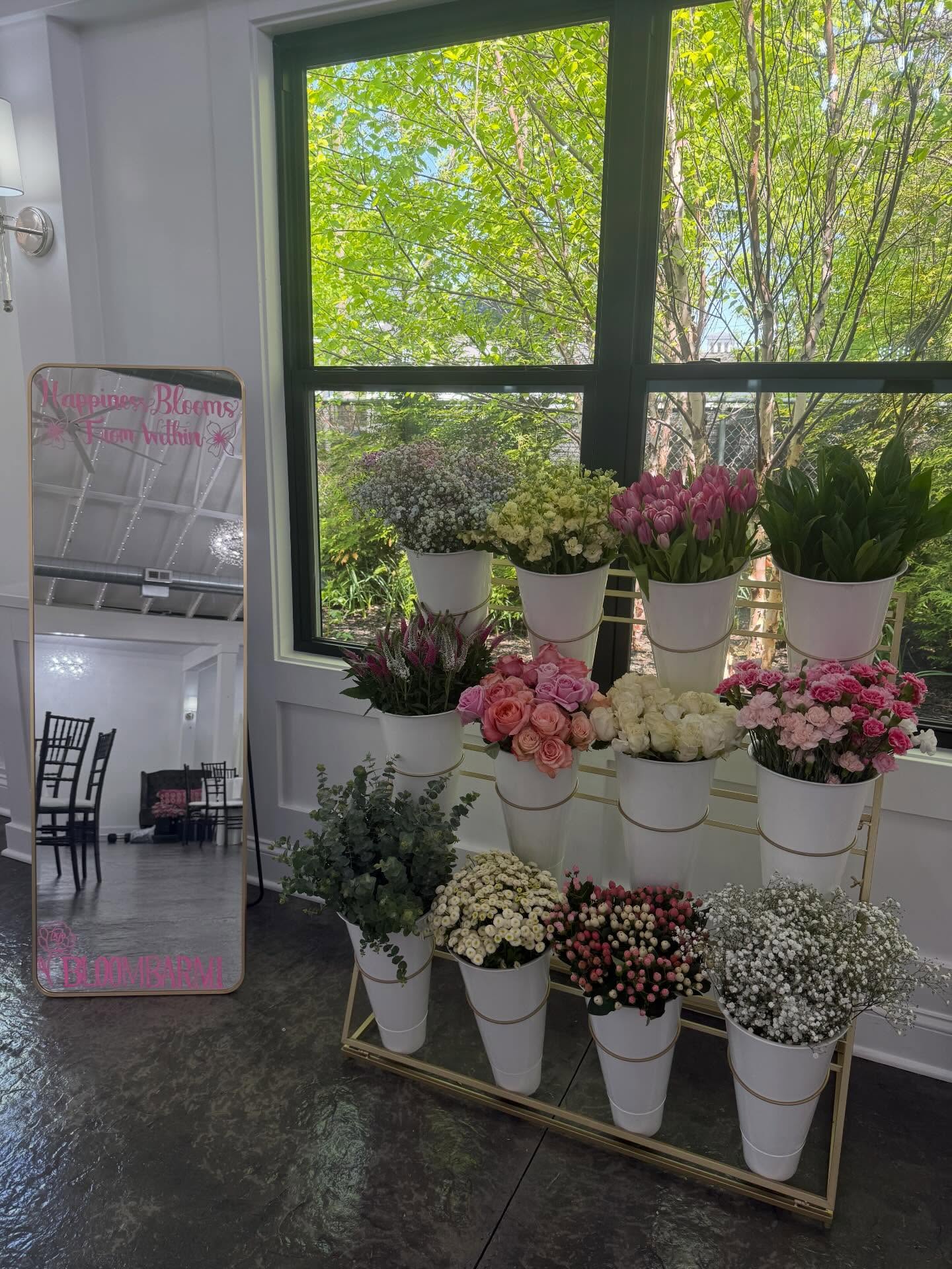 Bloom Bar tiered display with tulips, roses and baby's breath by a bright window