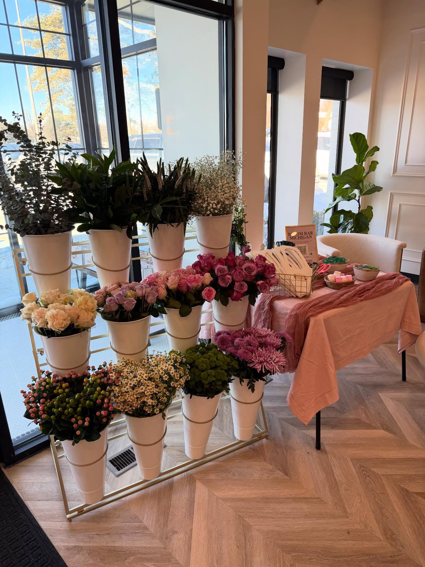 Bloom Bar display with roses and mums beside a pink styled table